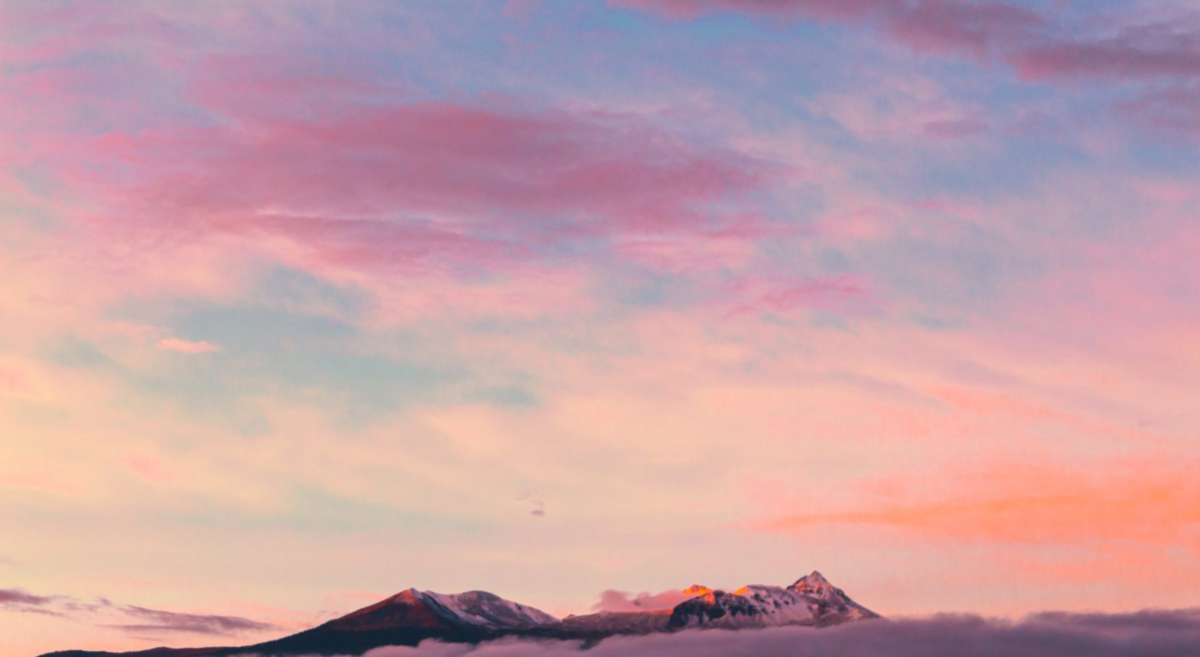 Pastel multi-colored sky above the tops of rocky mountains