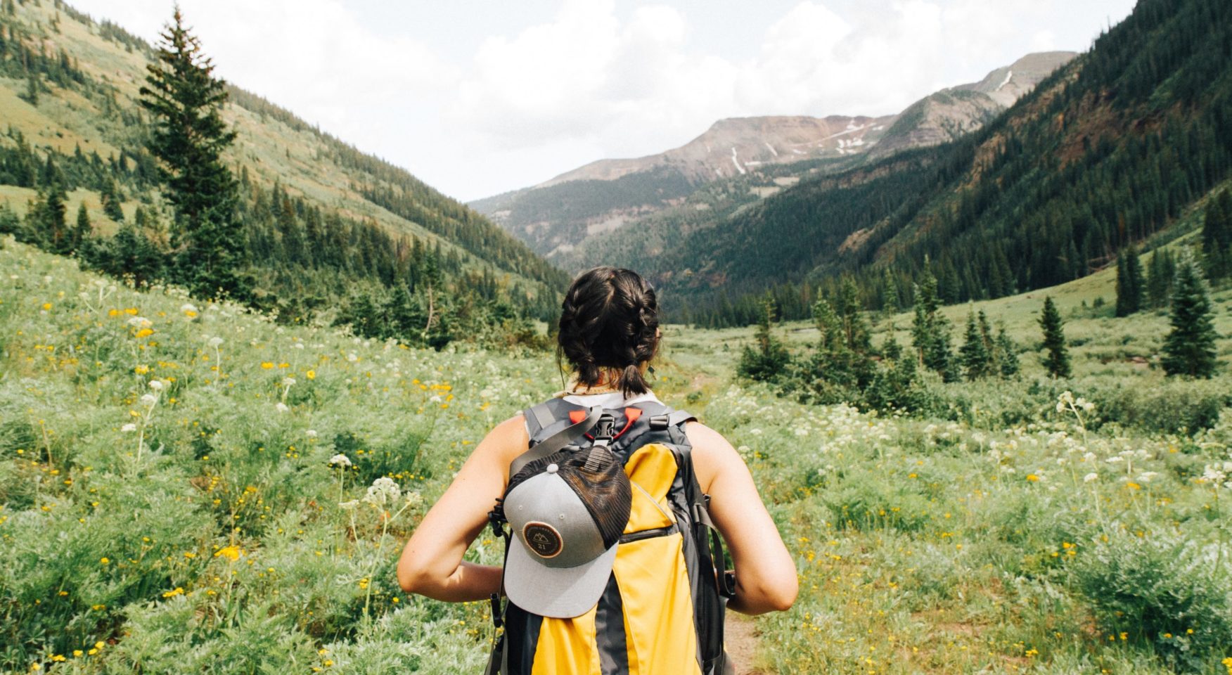 woman hiking with yellow backpack