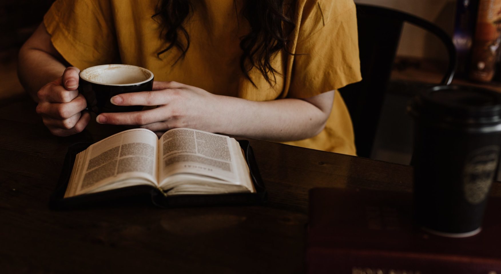 woman in yellow shirt studying the bible