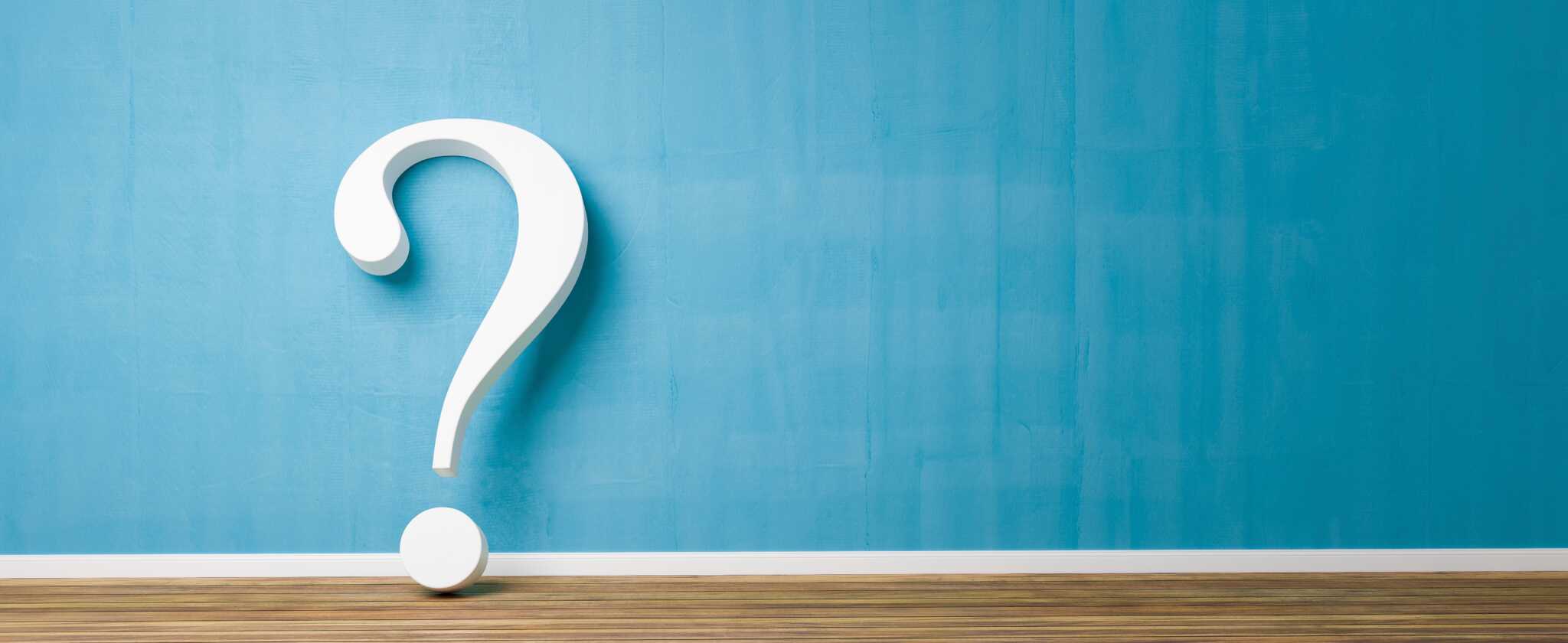 white question mark against blue wall