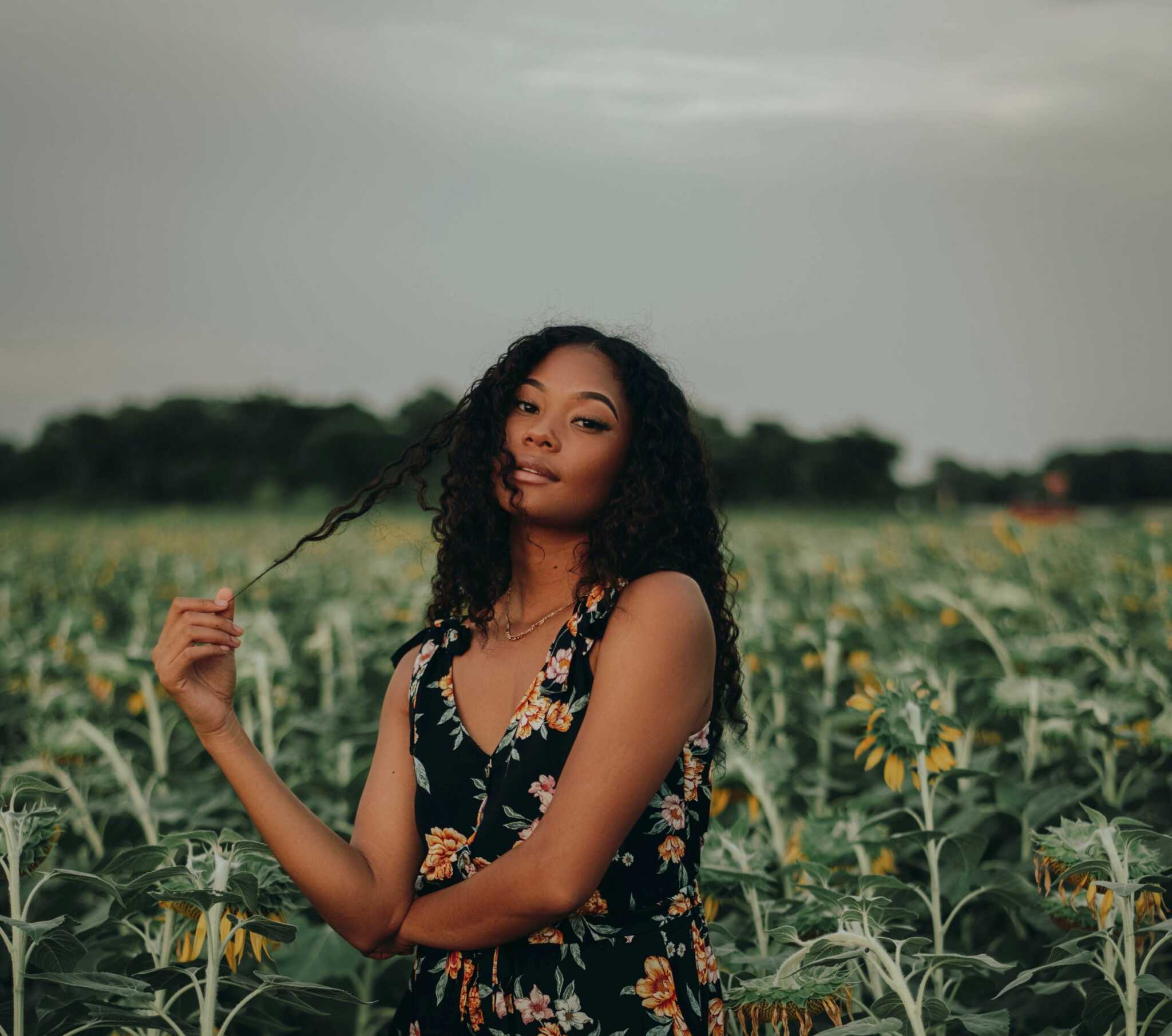 woman in sunflower field at sunset